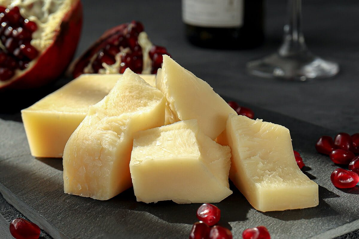 Slices of hard cheese on a black serving board